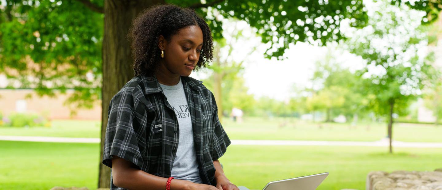 A student looking at a computer outside